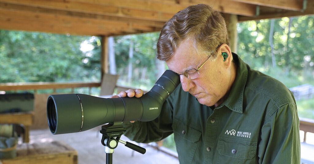 Vortex-Razor-HD-Spotting-Scope_7 (1) Person using a spotting scope outdoors.
